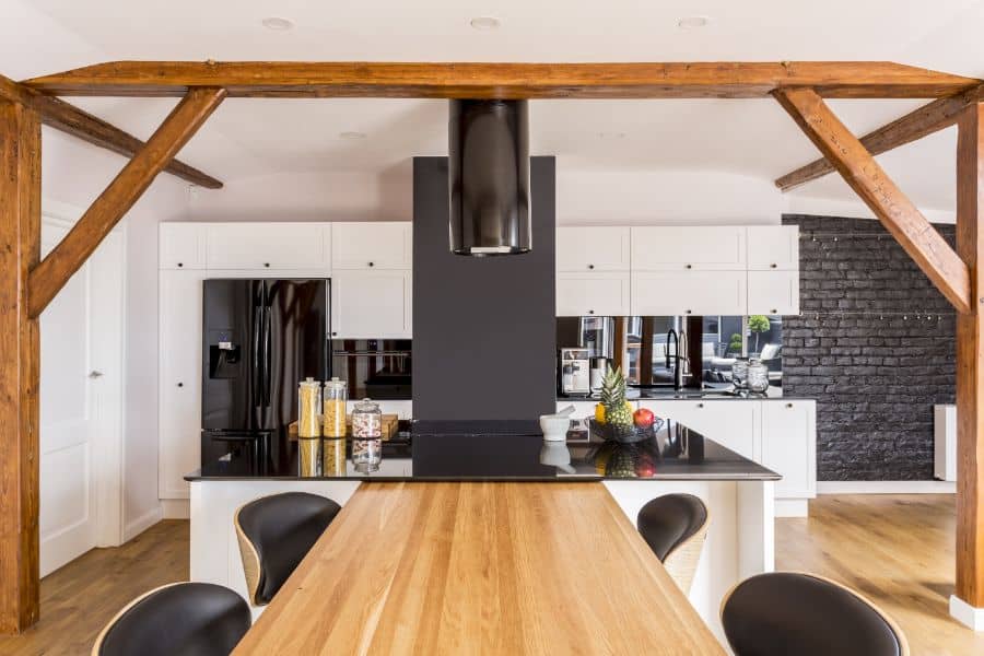 exposed wood beam white modern kitchen black brick accent wall