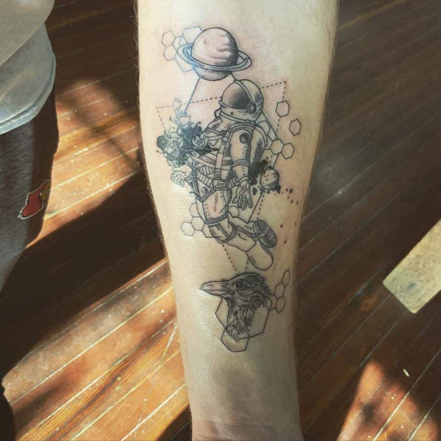 Forearm tattoo featuring a floating astronaut, geometric hexagons, a planet, and a raven, blending cosmic and surreal elements in fine detail.