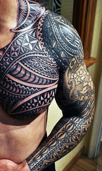 Person with intricate tribal tattoos covering chest, shoulder, and full arm