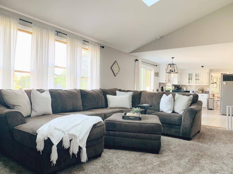 modern farmhouse open plan kitchen living room gray sectional couch gray carpet
