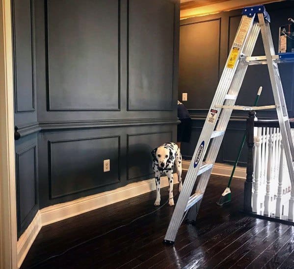 Chic dining room with black-painted chair rail molding and dark wood flooring