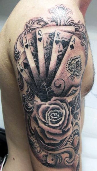 Tattoo of spade playing cards and a rose on a man's upper arm