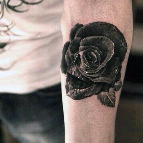 Black and grey tattoo of a skull seamlessly blended into a rose, creating a surreal and detailed design on the forearm.