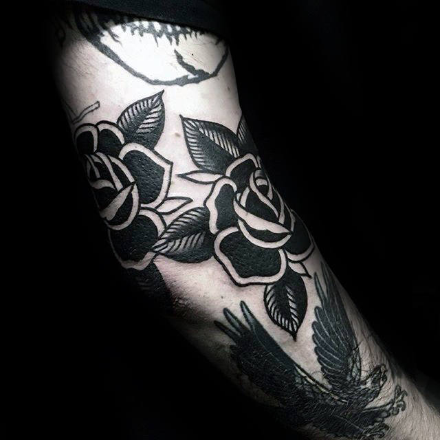 Close-up of a black rose tattoo on an arm