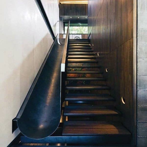 A modern staircase with a sleek, dark slide enhances the wooden interior space