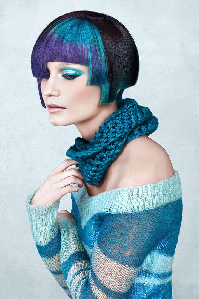 A bob haircut dyed in electric cyan and strikes of black