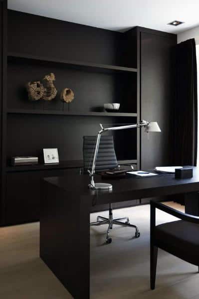 Minimalistic black office with a sleek desk, chair, and shelf decor featuring sculptures and books