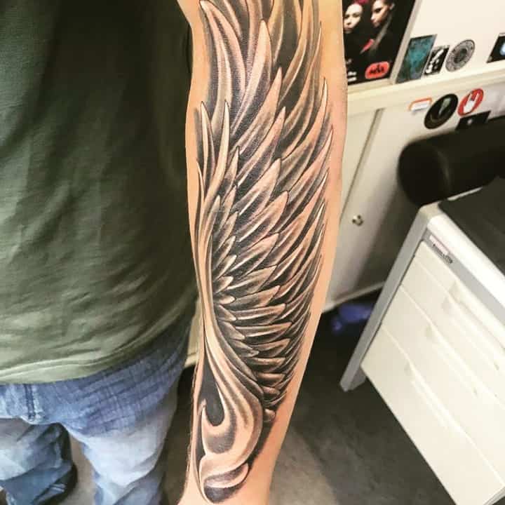Detailed and realistic angel wing tattoo, with intricate feathering and shading that creates depth and movement