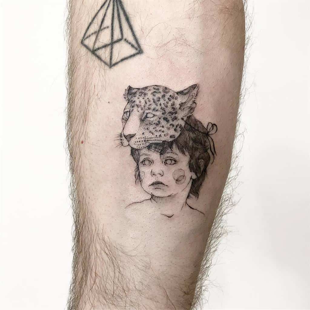 A surreal black and grey tattoo of a child with a jaguar's head placed on top, featuring intricate detailing and soft shading, placed on the forearm.