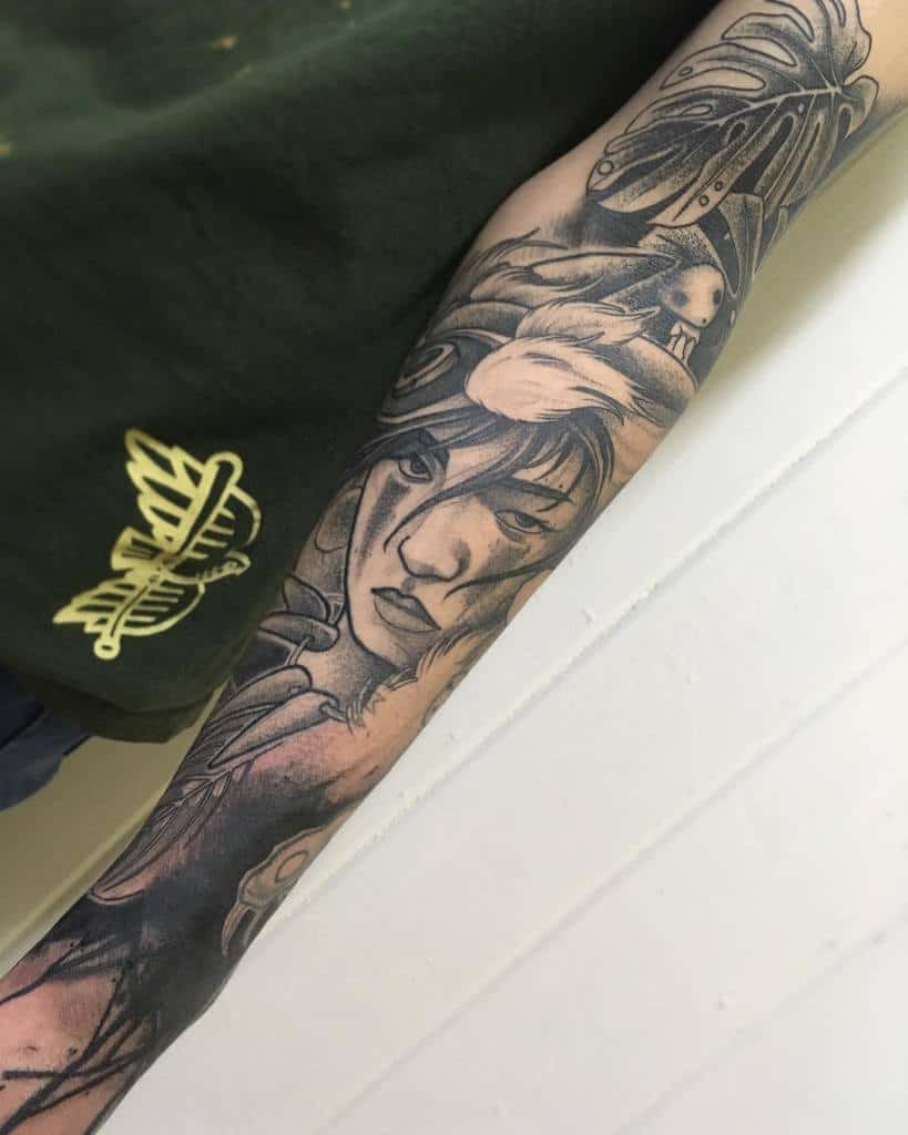 Black and grey full-sleeve tattoo of San from Princess Mononoke, featuring bold shading, intricate details, and forest elements.