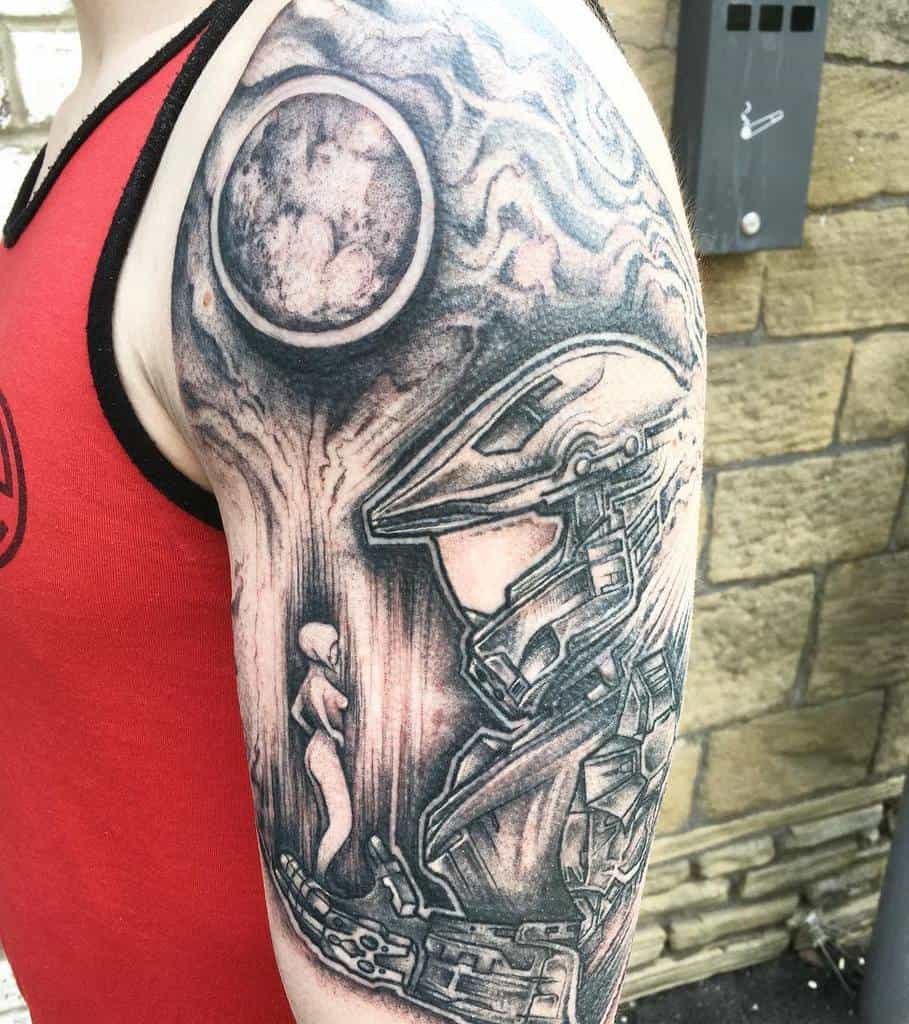 Black and gray Halo tattoo featuring Master Chief gazing at Cortana’s hologram, with a celestial background, inked as a detailed arm sleeve.
