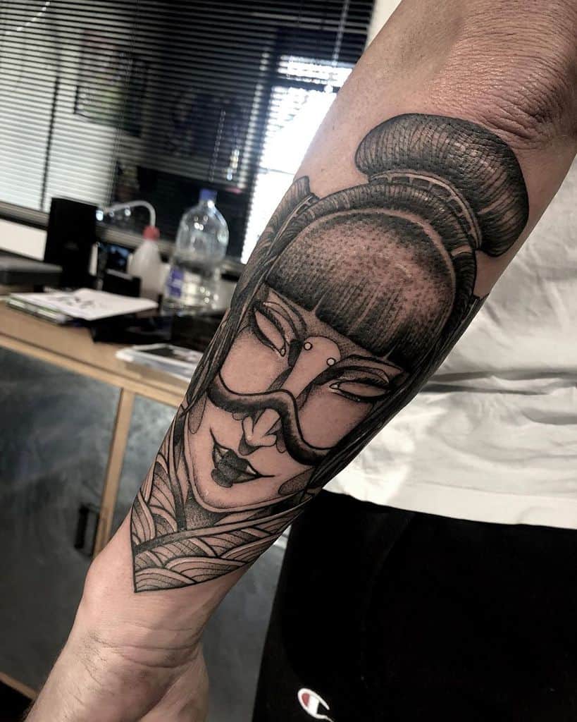 Bold black and gray tattoo of a futuristic Geisha with intricate shading, a sleek mask, and a traditional hairstyle, covering the forearm.