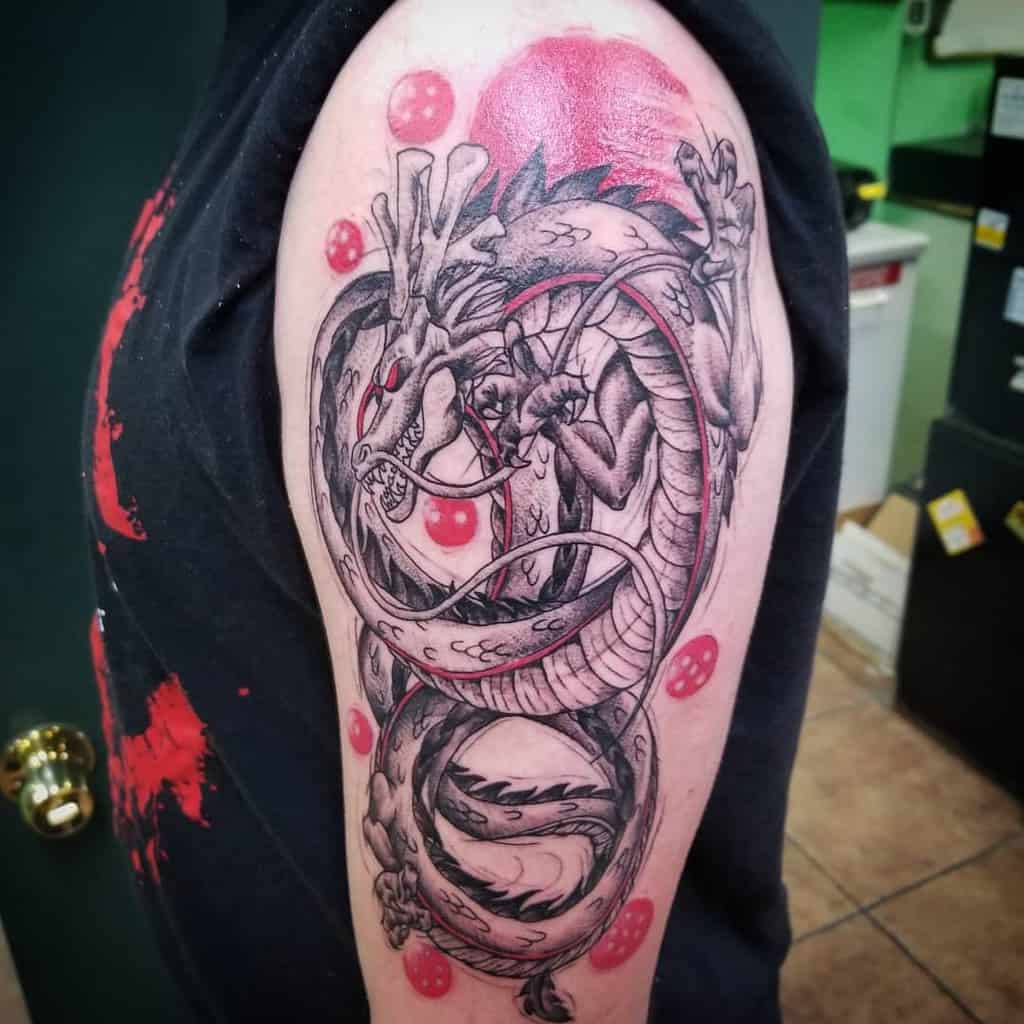 A detailed black-and-grey tattoo of Shenron, the dragon from *Dragon Ball*, coiling around multiple Dragon Balls, with intricate shading and dramatic contrast.