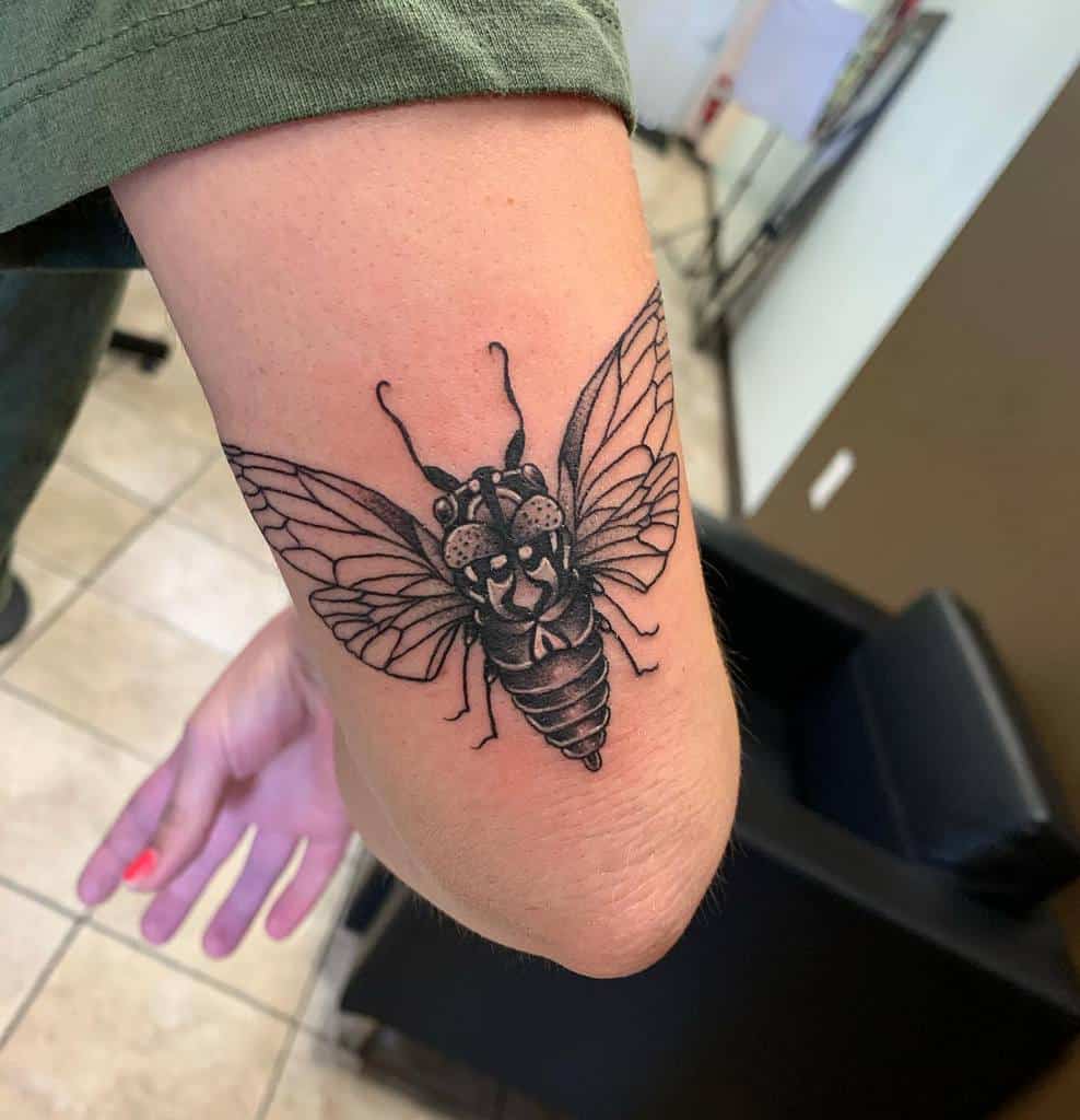 A detailed cicada tattoo on an elbow