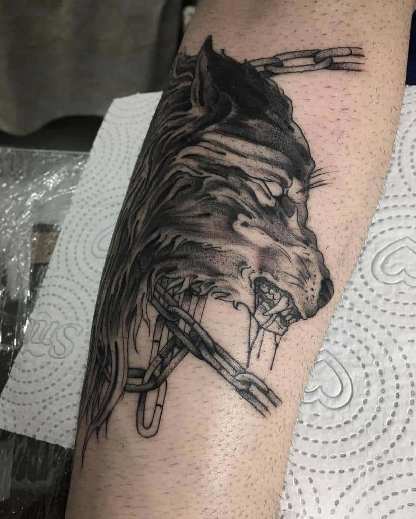 Bold blackwork wolf tattoo with chains, symbolizing strength and resilience, etched in a striking Norse-inspired style