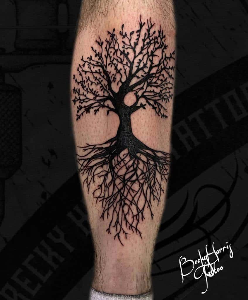 Bold blackwork calf tattoo featuring a detailed tree of life with intricate branches and sprawling roots