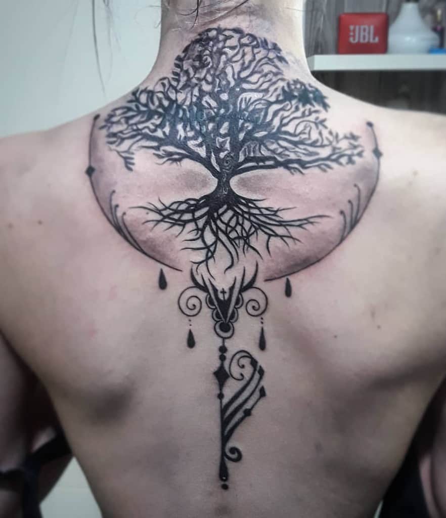Intricate back tattoo of a tree of life with sprawling roots and branches, adorned with ornate patterns and teardrop details