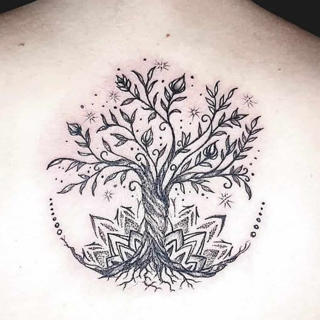 Delicate back tattoo of a tree of life with intricate leaves, roots, and surrounding stars, accented by mandala-inspired patterns