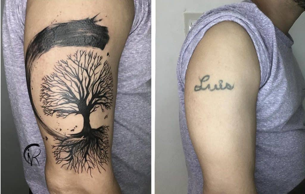 Arm tattoo featuring a detailed tree of life with sprawling roots, enclosed by a bold, abstract black brushstroke
