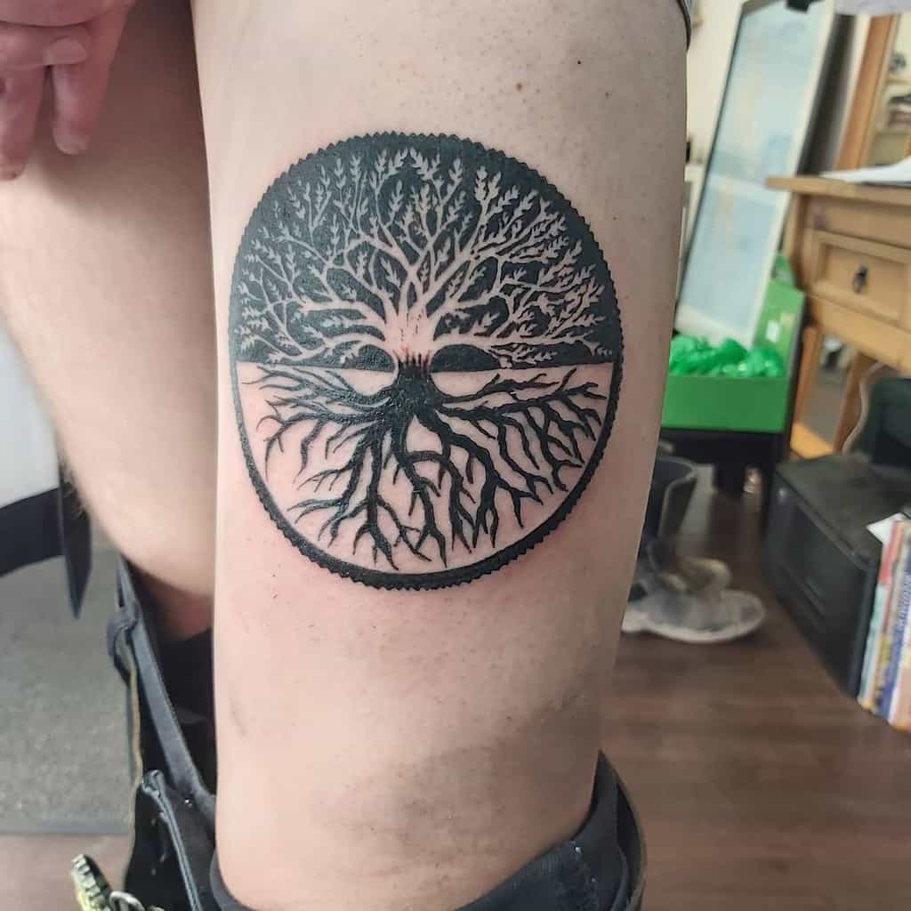Bold blackwork tattoo of a symmetrical tree of life enclosed in a circular frame, symbolizing balance and interconnectedness