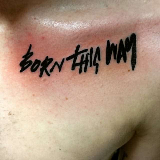 A tattoo in black script reads "Born This Way" on a person's upper chest