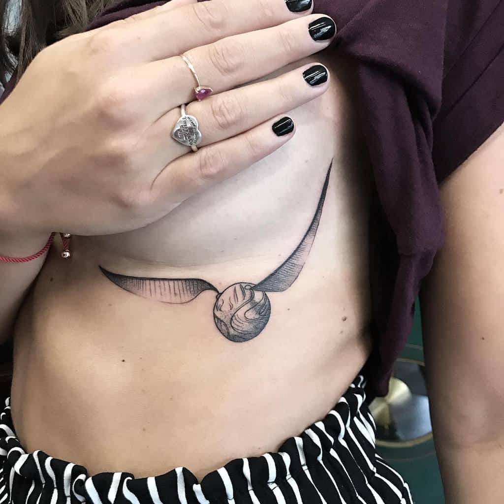 Golden Snitch tattoo with detailed wings inked, inspired by Harry Potter, symbolizing speed and victory