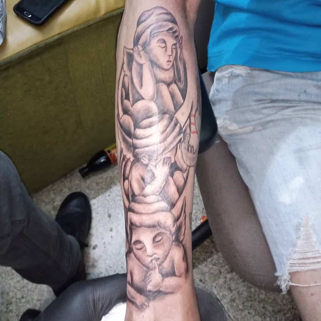 Black and grey forearm tattoo of three cherubic figures symbolizing 'Hear No Evil, See No Evil, Speak No Evil,' with soft shading
