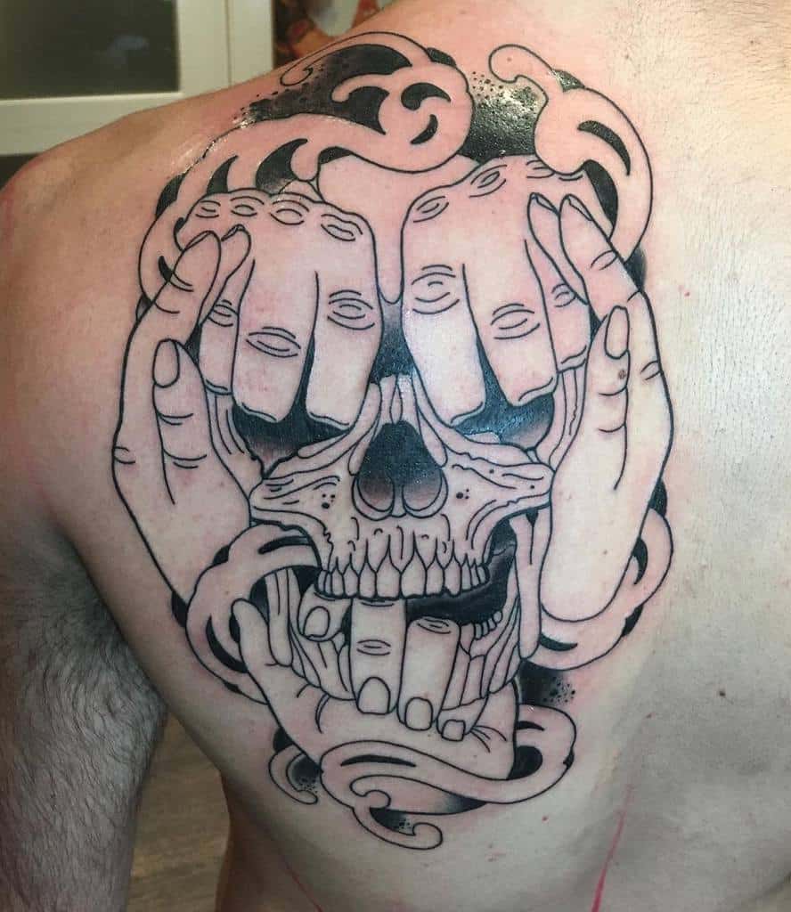 Tattoo of hands and swirling patterns forming a skull on a man's back