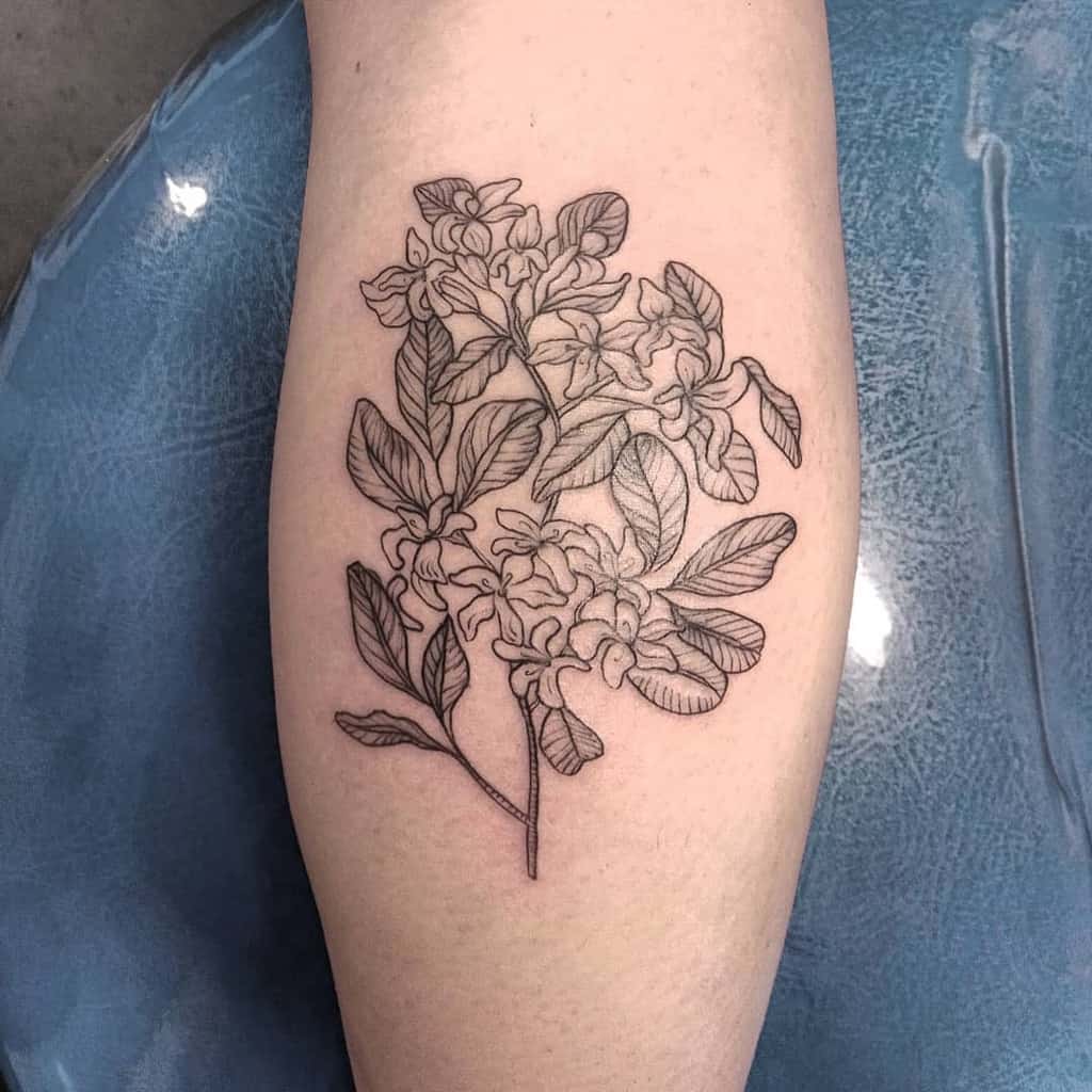 A tattoo of intricately detailed flowers and leaves on a calf