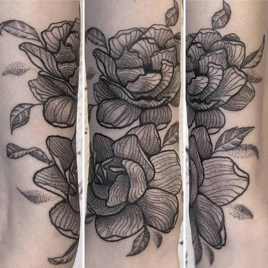 Black and grey jasmine tattoo with detailed shading and leaves on skin