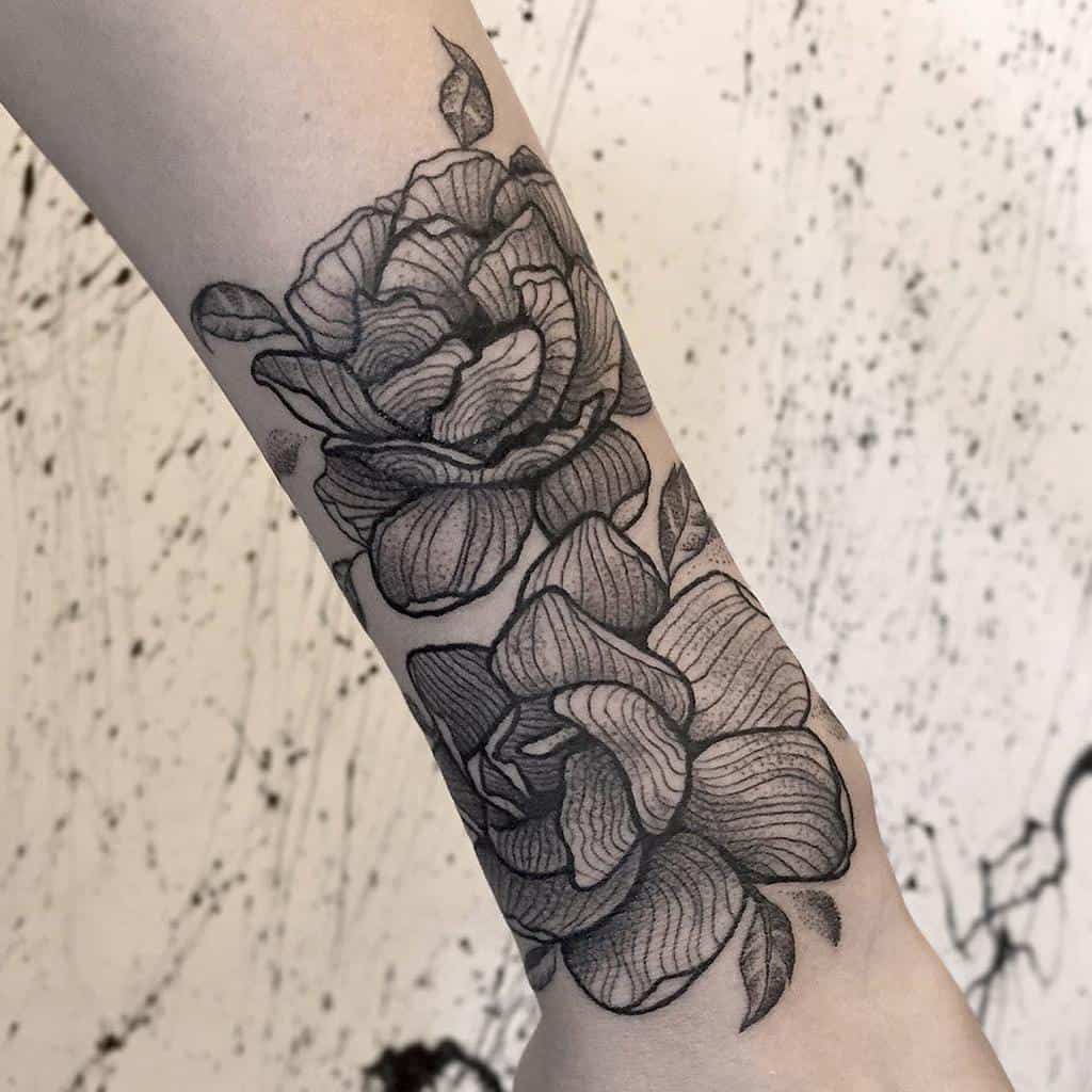 Black and gray floral tattoo of jasmine on a forearm