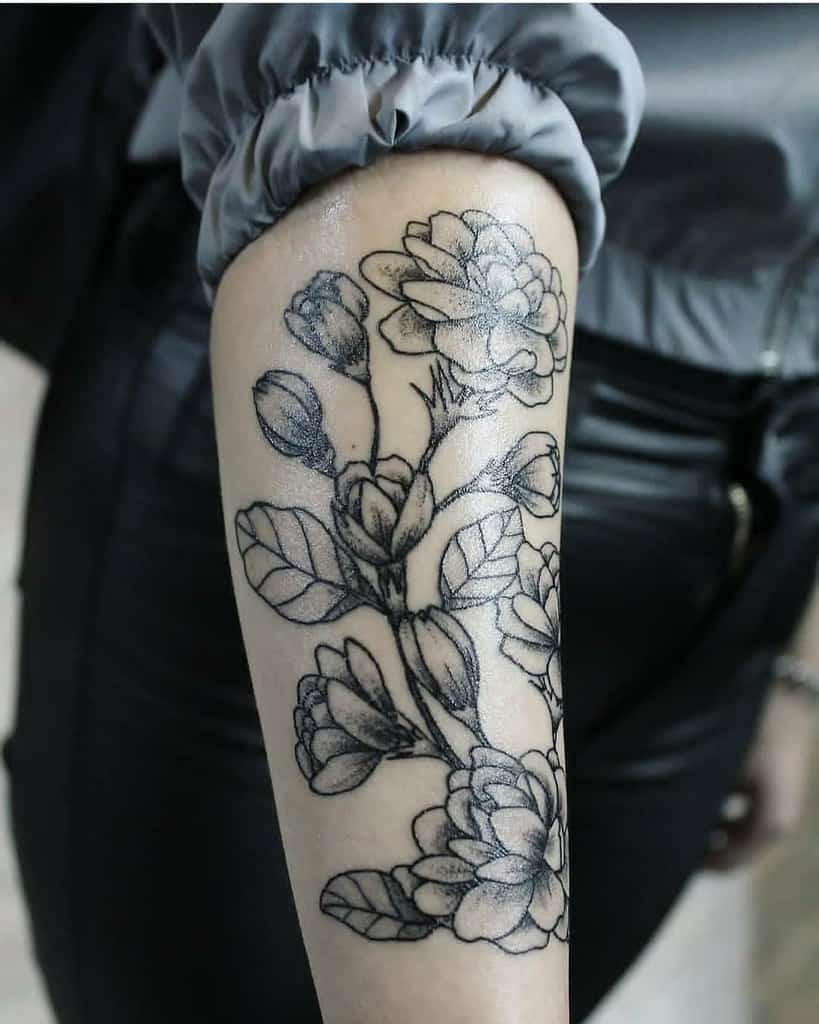 Black and white jasmine tattoo on a forearm