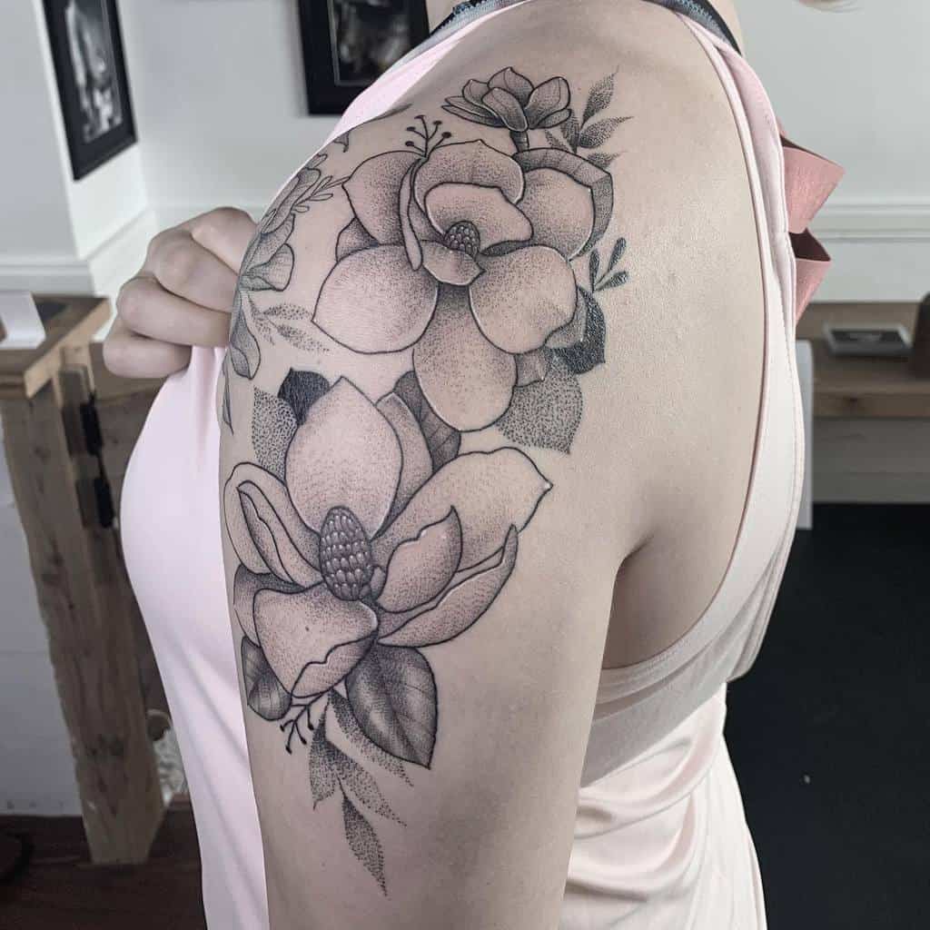 Woman with a magnolia floral tattoo elegantly gracing her shoulder and upper arm