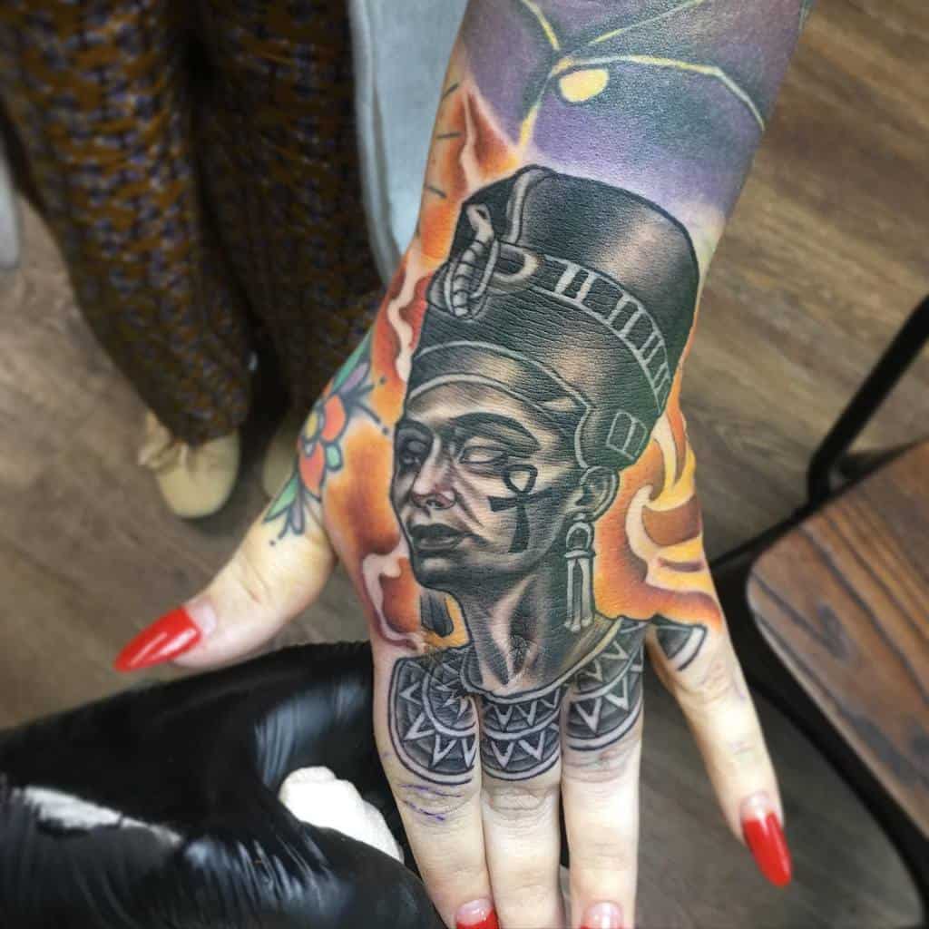 Hand tattoo of Queen Nefertiti with vibrant colors and intricate details
