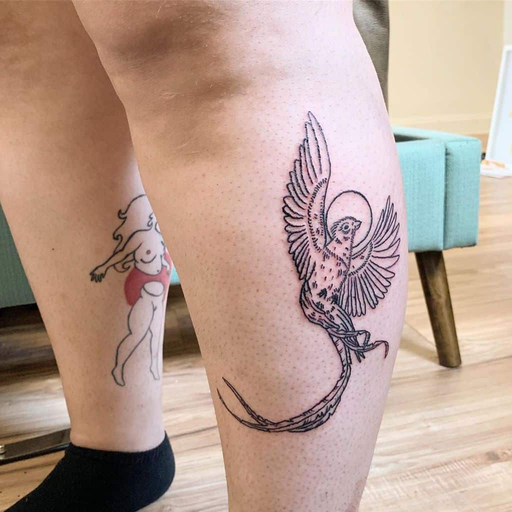 Blackwork quetzal tattoo on the calf, featuring an elegant bird with outstretched wings, a long tail, and a halo-like circle around its head