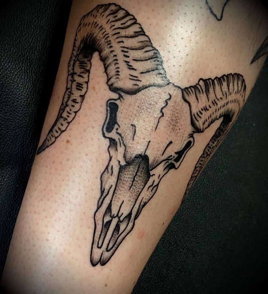 Tattoo of a ram skull with massive, curved horns