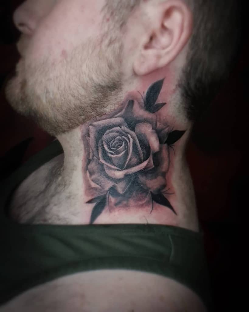 A tattoo of a large rose with lush leaves adorns the man's neck