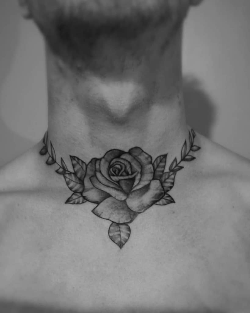 A black and gray rose tattoo elegantly adorns the neck, extending onto the chest