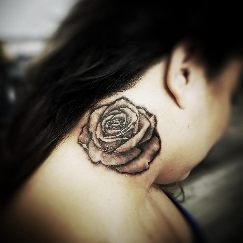 Black and grey shaded rose tattoo on the neck, showcasing intricate petal details and soft gradient shading for a realistic appearance