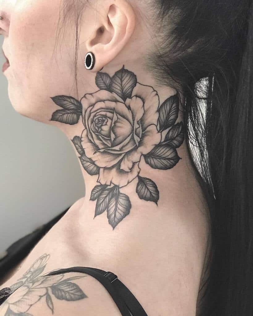 A woman with a detailed black rose tattoo intricately gracing her neck and extending artfully onto her shoulder