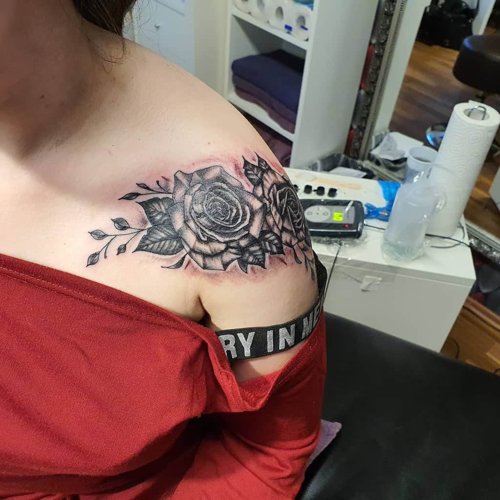 A black rose tattoo graces a woman's shoulder