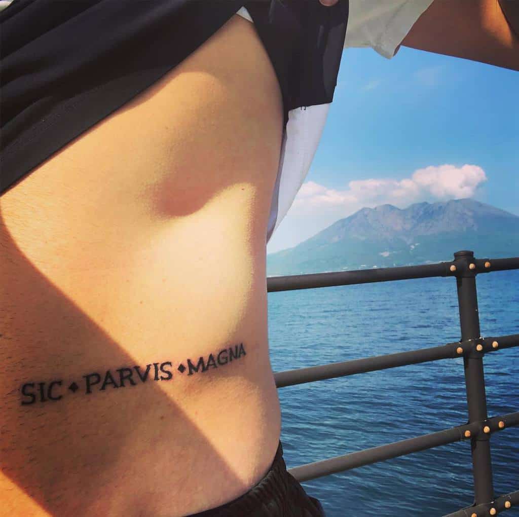 Tattoo on a man's side reads "Sic Parvis Magna"
