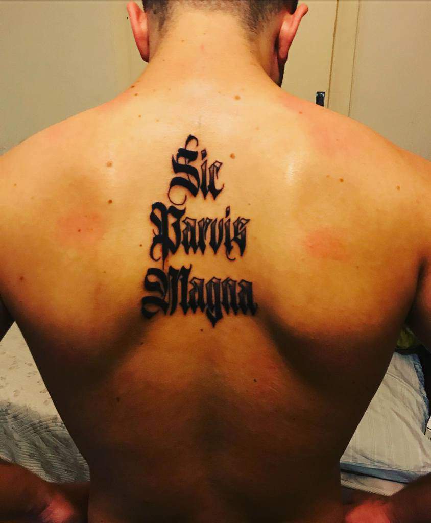Back tattoo with the phrase "Sic Parvis Magna" in bold, black lettering