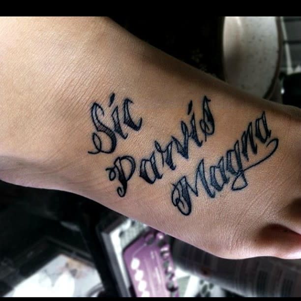 Tattoo on foot reading "Sic Parvis Magna" in elegant script