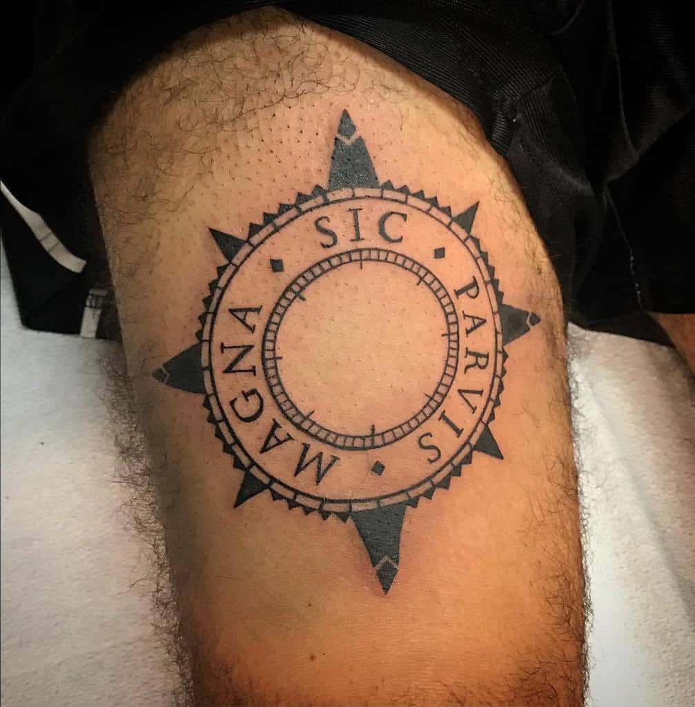 A compass tattoo with the Latin inscription "SIC PARVIS MAGNA" on a thigh
