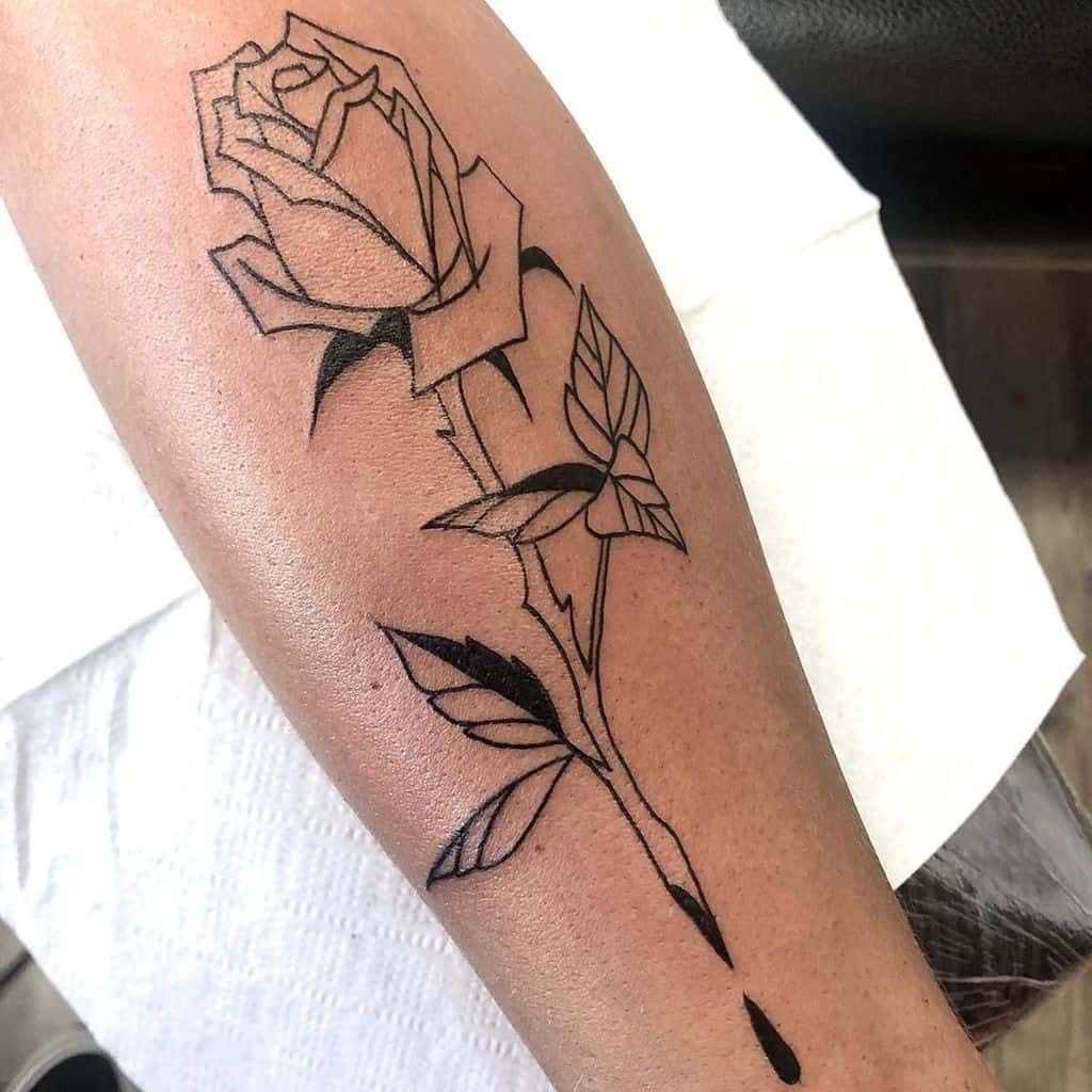 Outline tattoo of a rose on an arm featuring a dripping ink style design