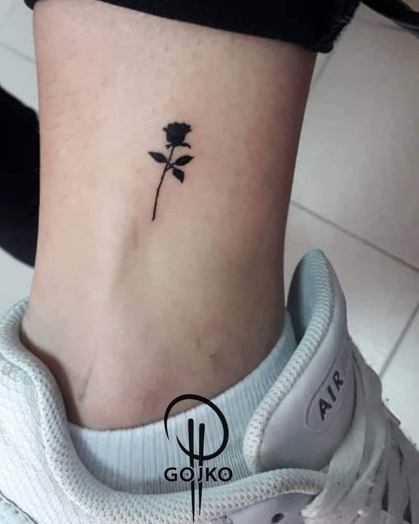 Small black rose tattoo on an ankle