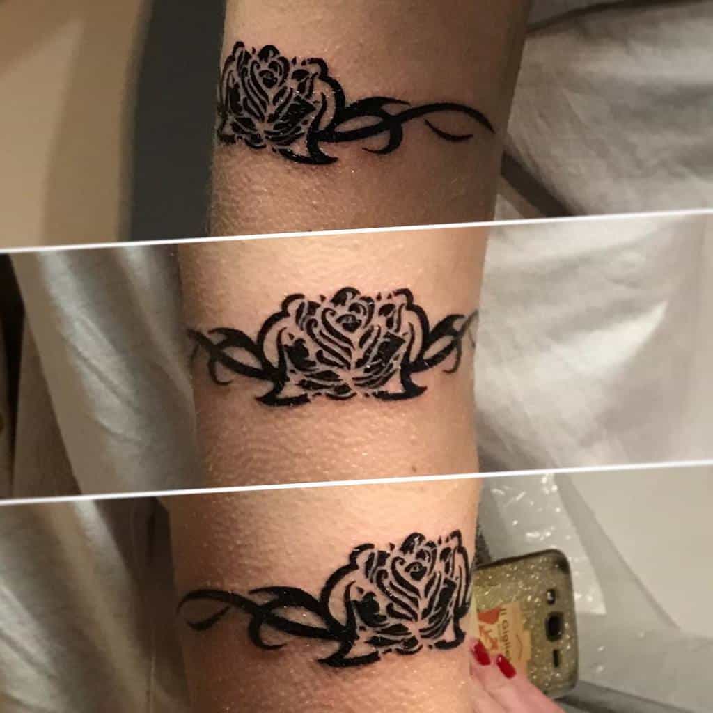 Tattoo of a tribal rose with intricate designs on an arm