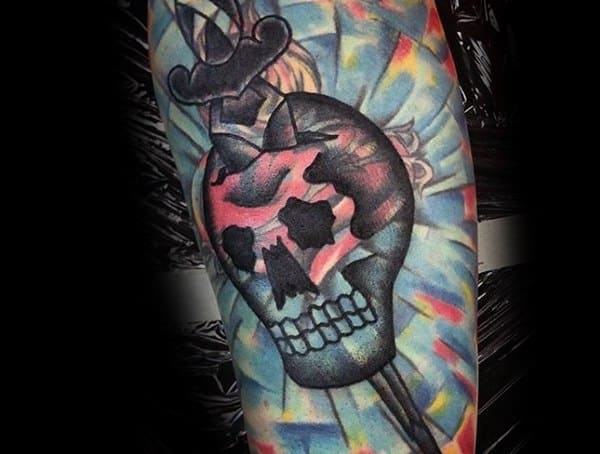 Neo-traditional tattoo of a skull with a dagger, featuring bold black outlines, vibrant colors, and dynamic shading for a striking effect.