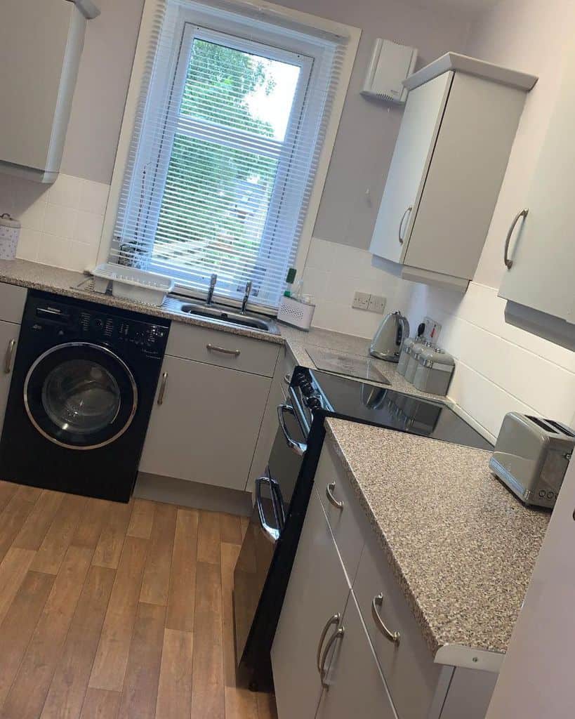small gray corner kitchen black washing machine and overn